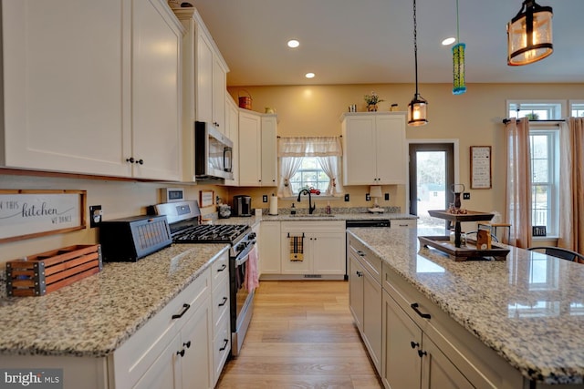 kitchen featuring appliances with stainless steel finishes, sink, hanging light fixtures, and a kitchen island