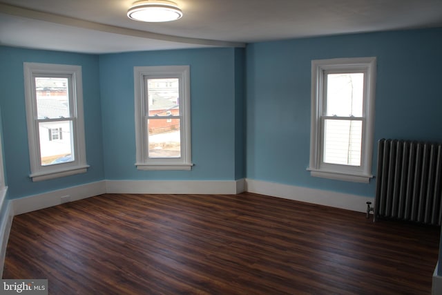 empty room with radiator and dark wood-type flooring