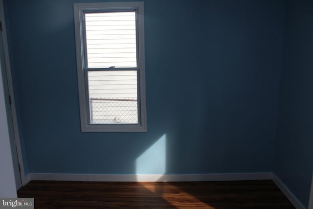 unfurnished room with dark wood-type flooring