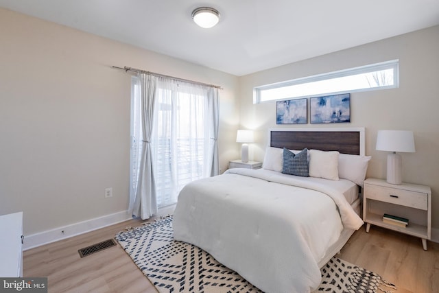 bedroom featuring multiple windows and light hardwood / wood-style flooring