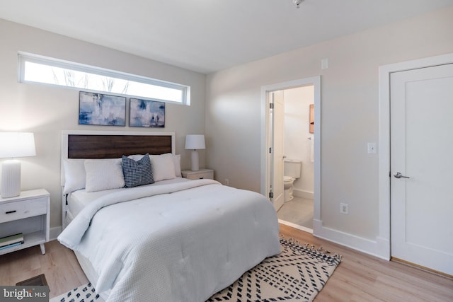 bedroom with ensuite bath and light wood-type flooring