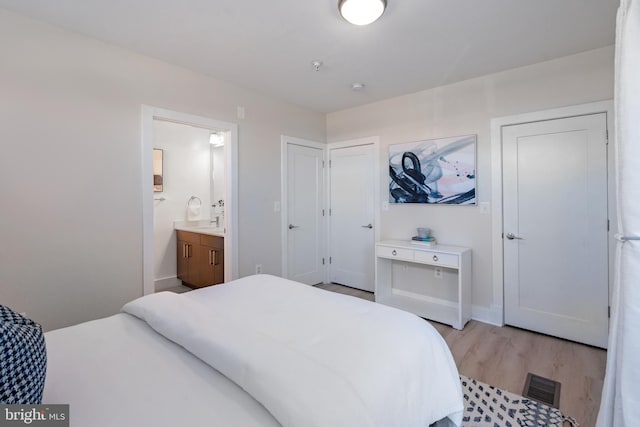 bedroom featuring ensuite bath and light hardwood / wood-style flooring