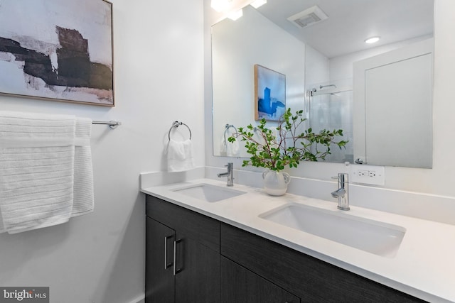 bathroom featuring vanity and a shower with door