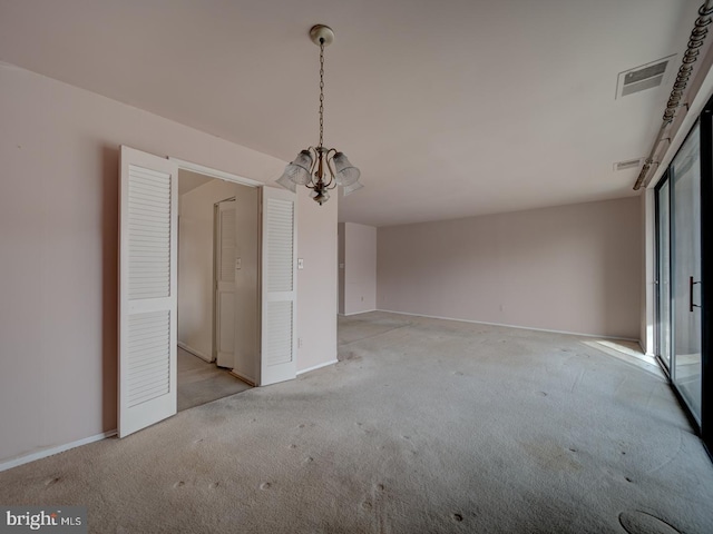 unfurnished dining area featuring an inviting chandelier and light carpet