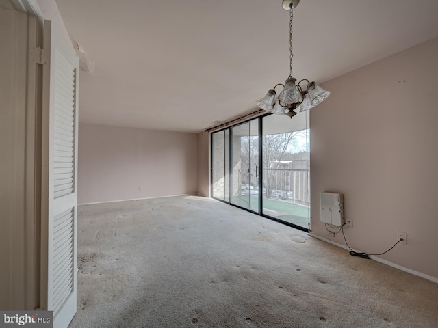 interior space featuring floor to ceiling windows, light carpet, and a notable chandelier