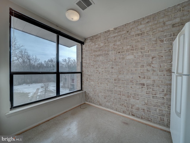 unfurnished room with brick wall