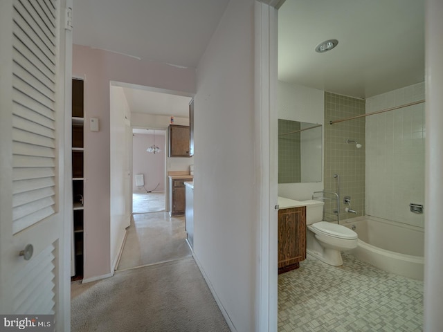 full bathroom featuring tiled shower / bath combo, vanity, and toilet