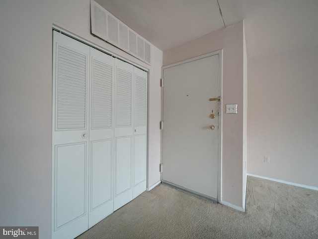 interior space featuring light colored carpet and a closet