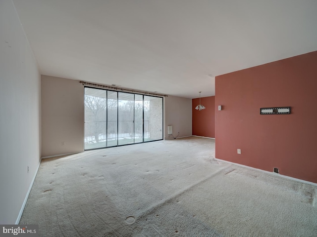 carpeted spare room featuring expansive windows