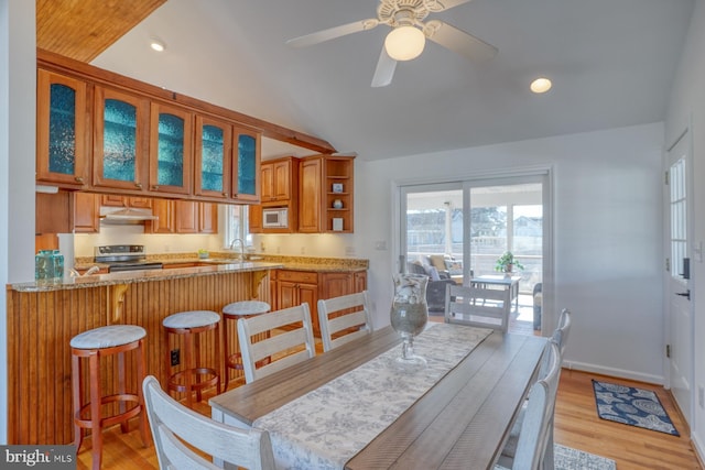 dining area featuring sink, ceiling fan, and light wood-type flooring