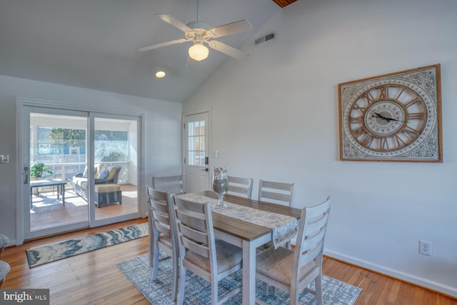 dining space with high vaulted ceiling, ceiling fan, and light wood-type flooring