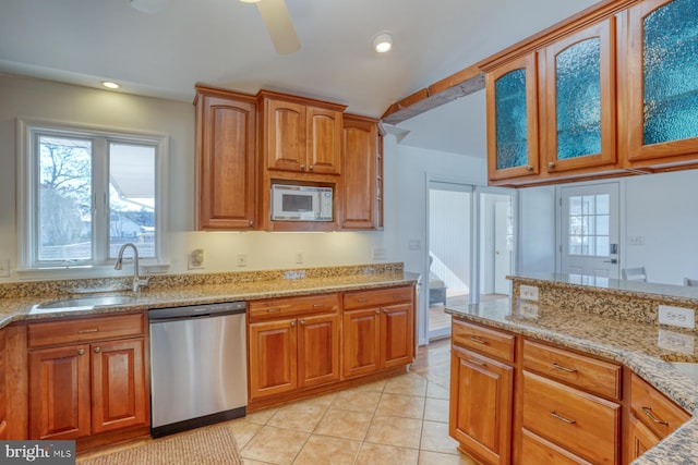 kitchen featuring light tile patterned flooring, sink, light stone counters, dishwasher, and white microwave