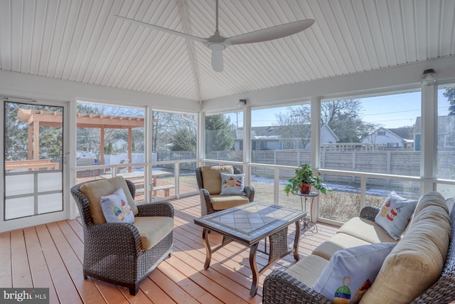 sunroom / solarium with plenty of natural light, lofted ceiling, and ceiling fan