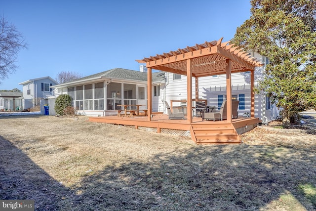 rear view of property with a pergola, a lawn, a sunroom, and a deck