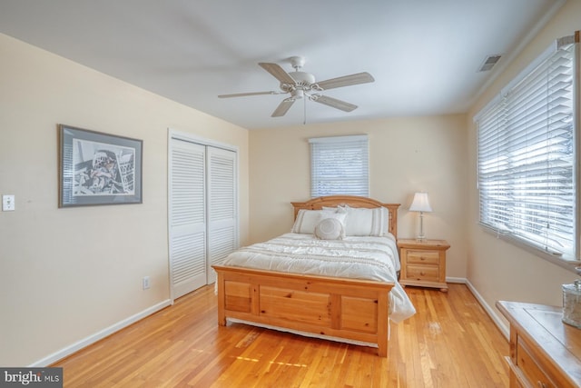 bedroom with ceiling fan, light wood-type flooring, and a closet