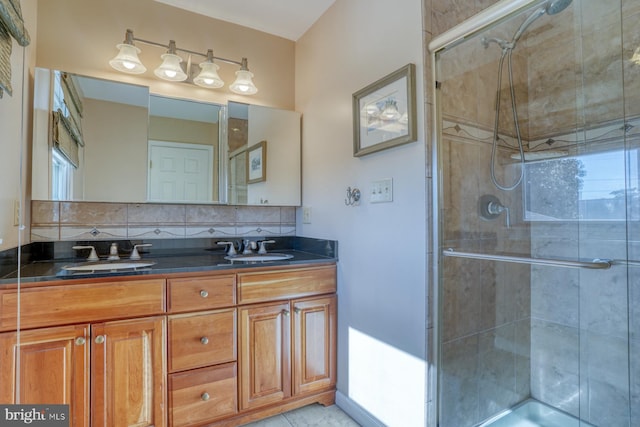 bathroom featuring tasteful backsplash, vanity, and a shower with door