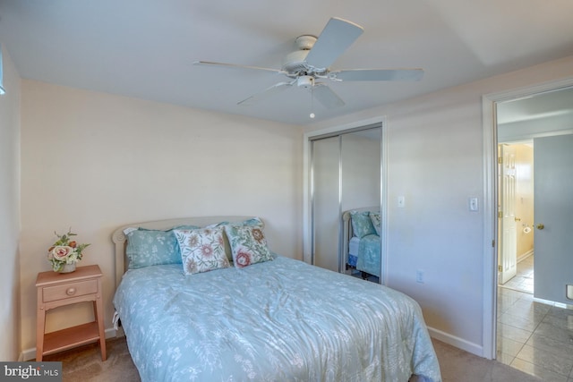 bedroom with ceiling fan, tile patterned floors, and a closet