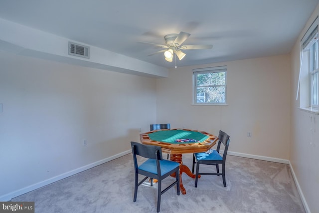 carpeted dining room with ceiling fan