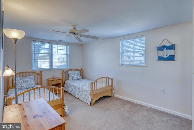 carpeted bedroom featuring ceiling fan and multiple windows