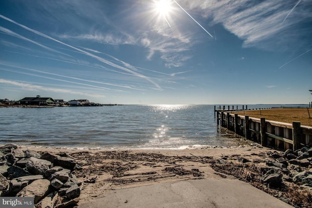 view of dock featuring a water view and a view of the beach