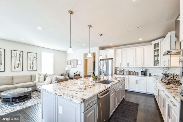 kitchen with pendant lighting, an island with sink, white cabinets, and appliances with stainless steel finishes