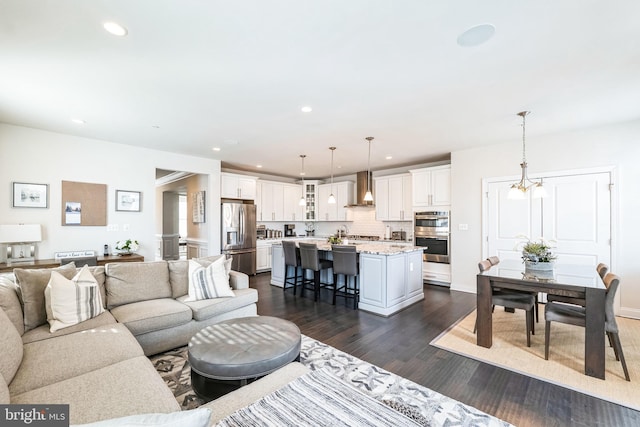 living room with an inviting chandelier and dark hardwood / wood-style floors