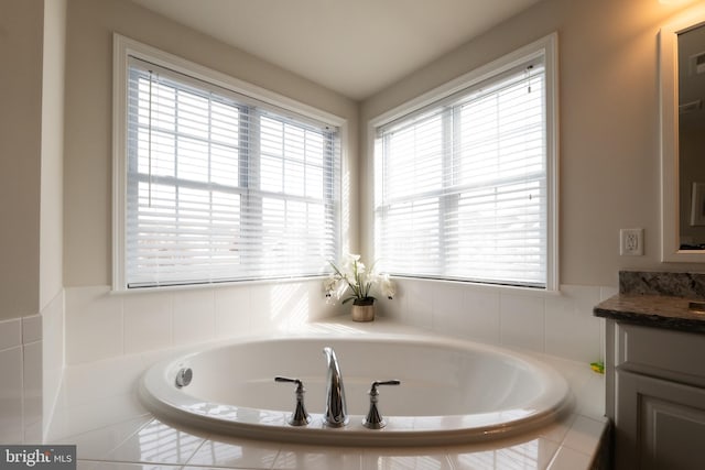 bathroom with vanity and a relaxing tiled tub