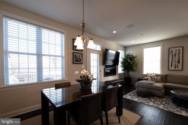 dining area with hardwood / wood-style floors and a notable chandelier