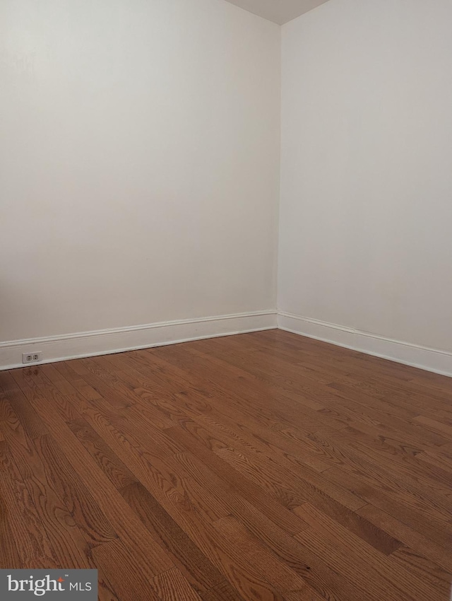 spare room featuring dark wood-type flooring