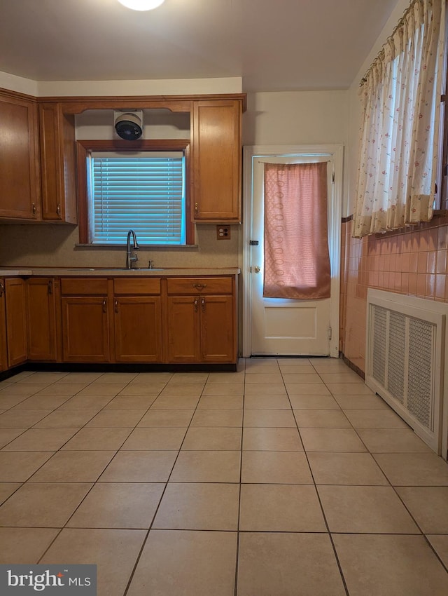 kitchen with sink, radiator, and light tile patterned floors