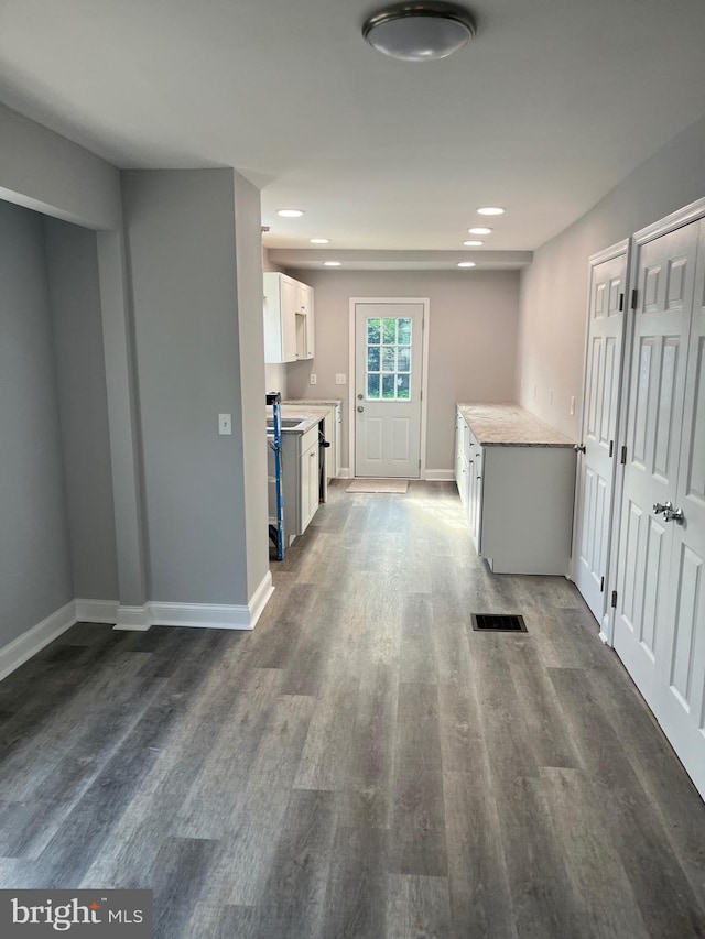 kitchen with dark hardwood / wood-style flooring and white cabinets