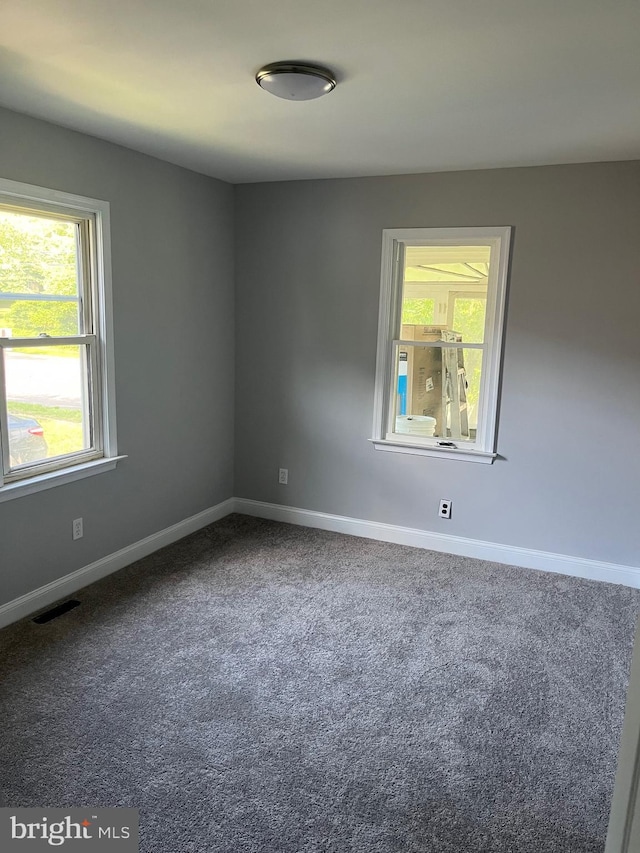 carpeted spare room featuring plenty of natural light