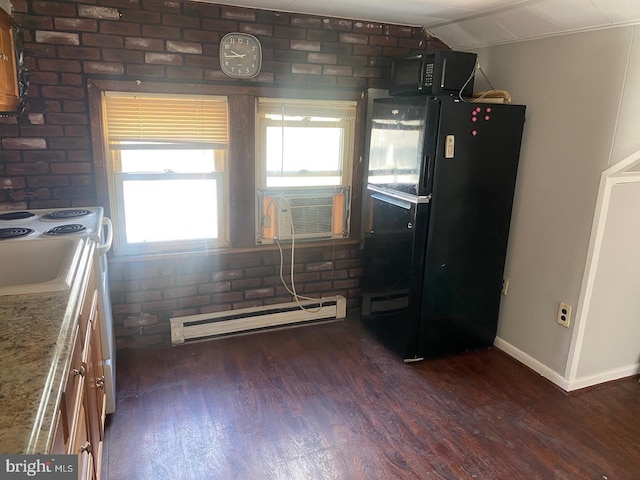 kitchen featuring dark hardwood / wood-style flooring, a baseboard heating unit, black appliances, and brick wall