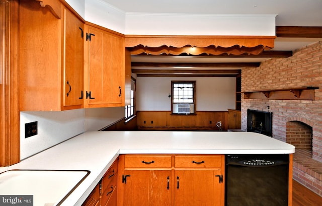 kitchen featuring a wainscoted wall, a peninsula, a sink, light countertops, and beamed ceiling