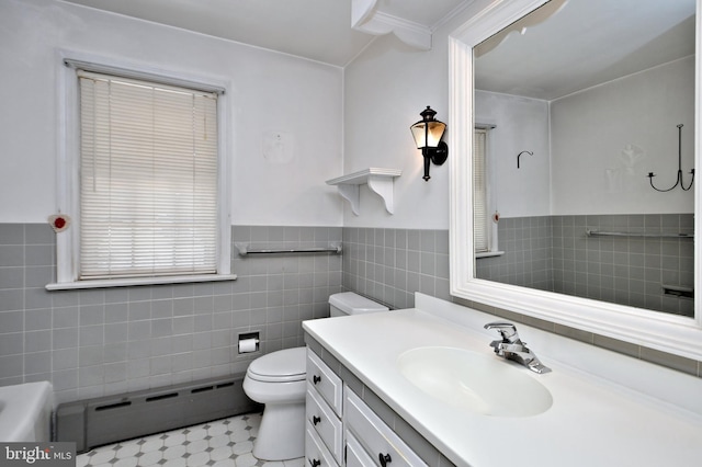 bathroom featuring vanity, wainscoting, tile walls, toilet, and baseboard heating