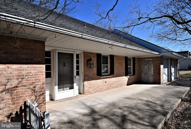 exterior space with brick siding, driveway, and a garage