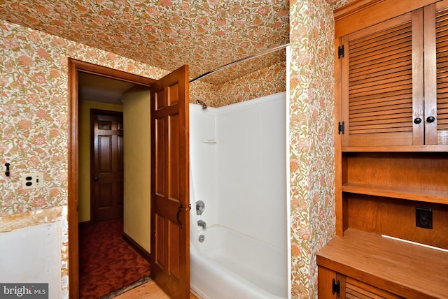 full bath featuring wallpapered walls and shower / tub combination