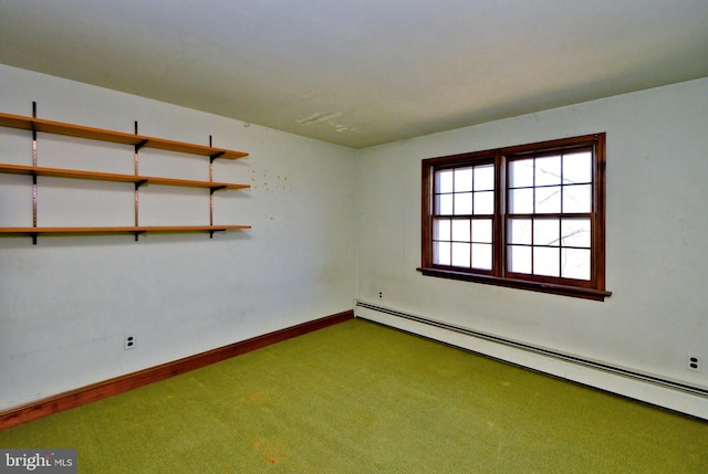 spare room featuring a baseboard heating unit, carpet flooring, and baseboards