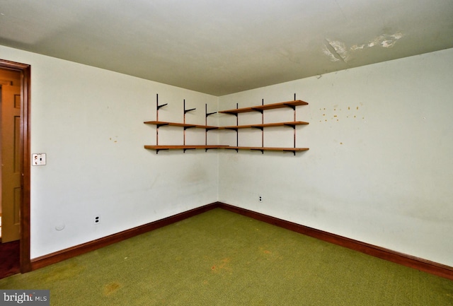 spare room featuring carpet flooring and baseboards