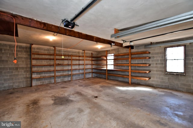 garage featuring a garage door opener and concrete block wall