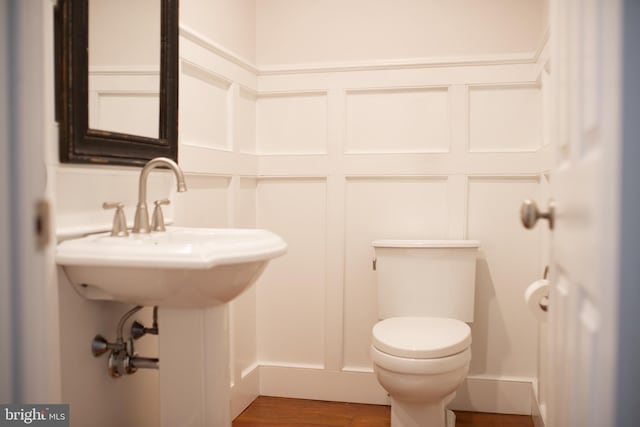 bathroom with hardwood / wood-style floors and toilet