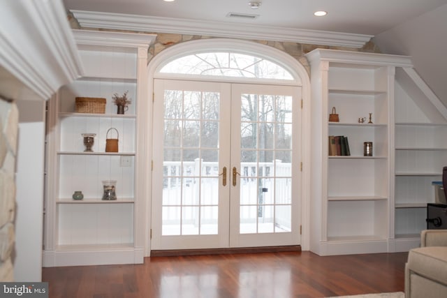 entryway with built in shelves, dark wood-type flooring, ornamental molding, and french doors