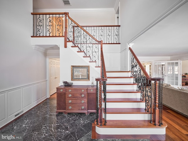 stairs with ornamental molding and a high ceiling