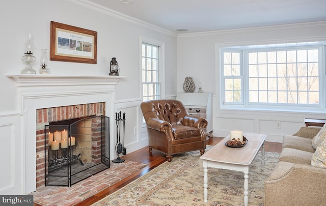 sitting room featuring crown molding, wood-type flooring, and a fireplace