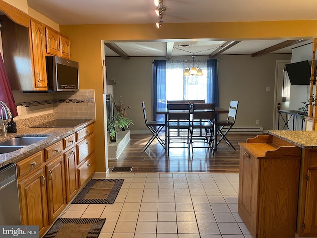 kitchen featuring sink, light tile patterned floors, backsplash, hanging light fixtures, and stainless steel appliances