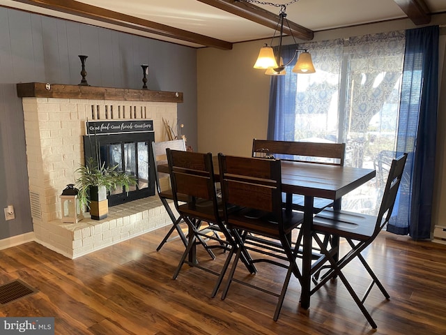 dining area featuring dark hardwood / wood-style flooring, beam ceiling, and a fireplace