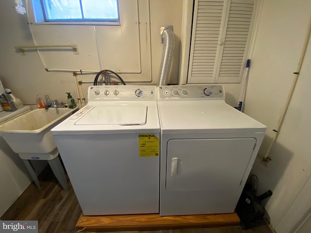 clothes washing area featuring washing machine and clothes dryer, dark hardwood / wood-style floors, and sink