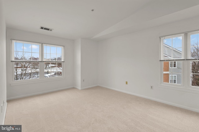 spare room featuring vaulted ceiling and light carpet