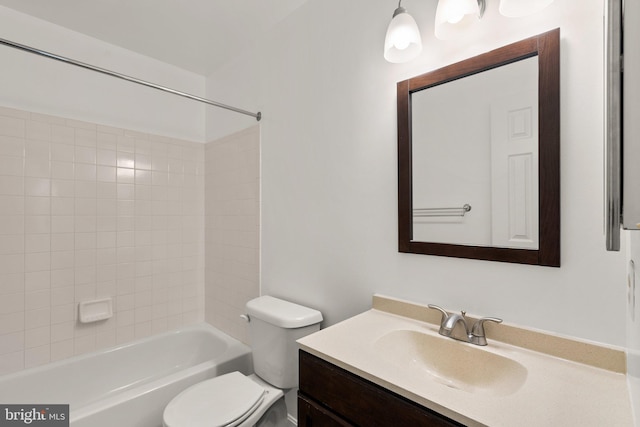 full bathroom featuring tiled shower / bath, vanity, and toilet