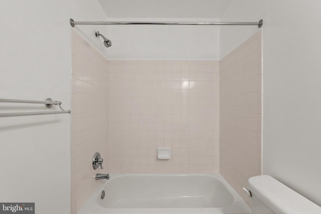 bathroom with toilet and tiled shower / bath